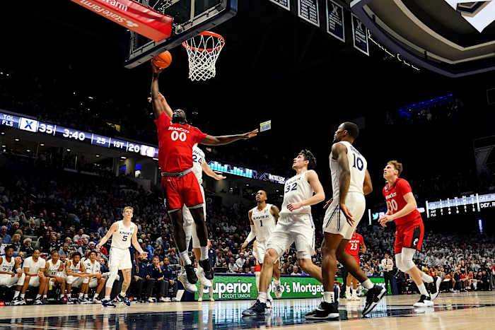 Cincinnati Bearcats forward Abdul Ado (00) rises to the basket as Xavier Musketeers forward Jack Nunge (24) defends in the first half of the 89th Annual Crosstown Shootout college basketball game, Saturday, Dec. 11, 2021, at Cintas Center in Cincinnati. The Xavier Musketeers won, 83-63. Xavier Musketeers At Cincinnati Bearcats 89th Crosstown Shootout Dec 11